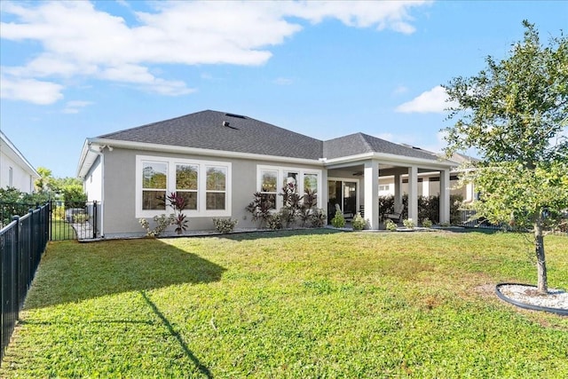 rear view of house featuring a lawn