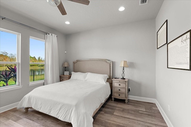 bedroom with ceiling fan and dark hardwood / wood-style floors