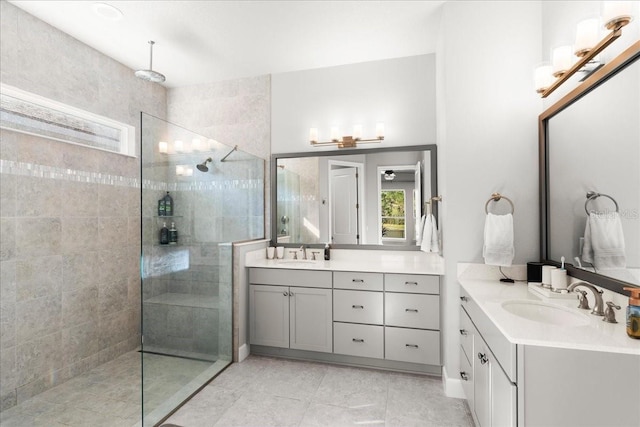 bathroom with a tile shower and vanity