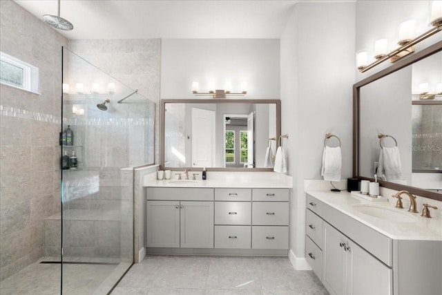 bathroom with tile patterned floors, vanity, and a tile shower