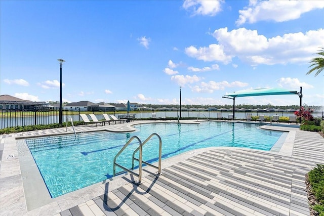 view of pool with a water view and a patio area