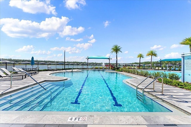 view of swimming pool with a patio area and a water view