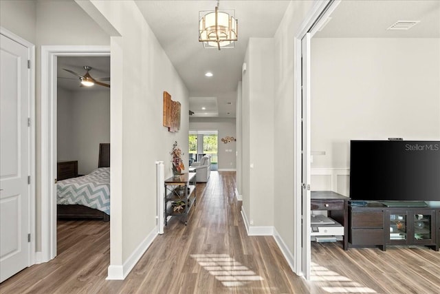 hall with hardwood / wood-style flooring and a notable chandelier