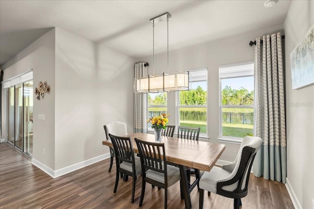 dining space featuring a water view, dark hardwood / wood-style floors, and a notable chandelier