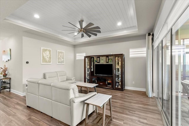 living room with hardwood / wood-style floors, wooden ceiling, a raised ceiling, crown molding, and ceiling fan