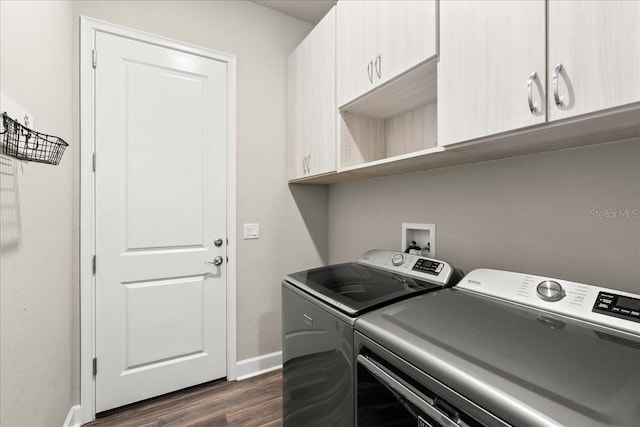 laundry room featuring cabinets, dark hardwood / wood-style floors, and independent washer and dryer