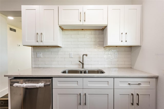 kitchen featuring dishwasher, sink, decorative backsplash, light stone counters, and white cabinetry