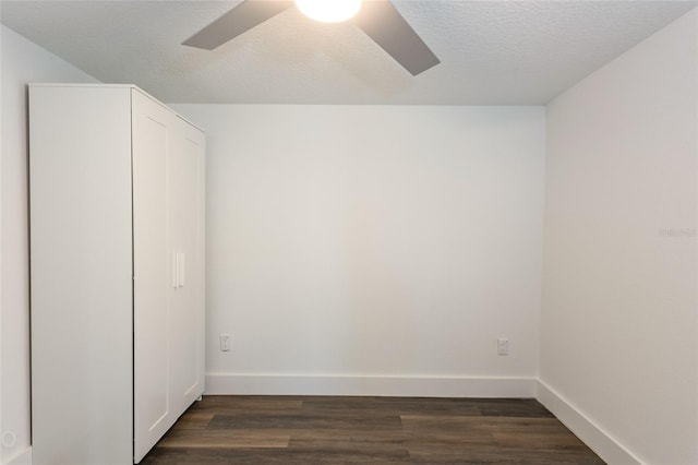 unfurnished bedroom with a textured ceiling, dark hardwood / wood-style floors, and ceiling fan