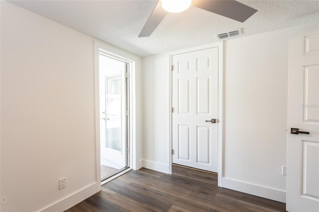 unfurnished bedroom with dark hardwood / wood-style flooring, a textured ceiling, and ceiling fan