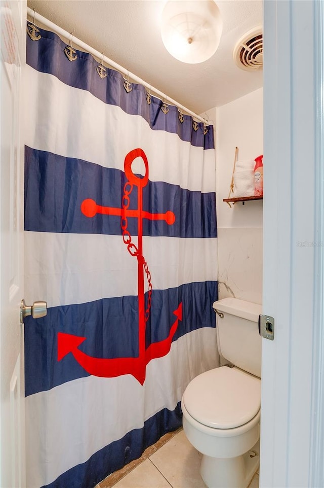 bathroom with curtained shower, tile patterned flooring, and toilet