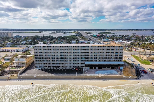 birds eye view of property with a water view and a beach view