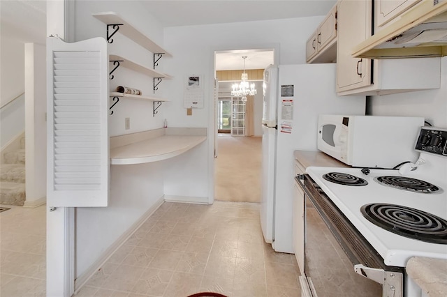 kitchen featuring white appliances, hanging light fixtures, and a notable chandelier