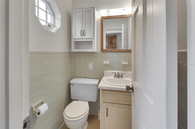 bathroom featuring vanity, toilet, and tile walls