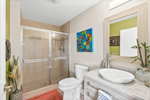 bathroom with vanity, toilet, and a shower with shower door