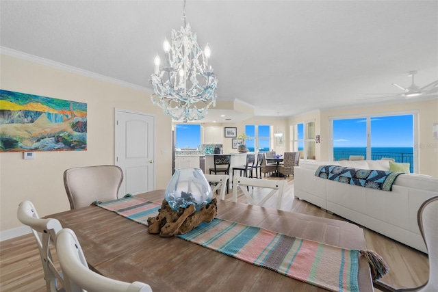 dining area with a water view, ceiling fan, ornamental molding, and light hardwood / wood-style floors