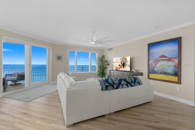 living room featuring a water view, light hardwood / wood-style flooring, ceiling fan, and crown molding