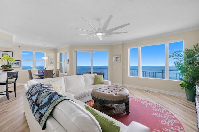 living room featuring a water view, light wood-type flooring, and crown molding