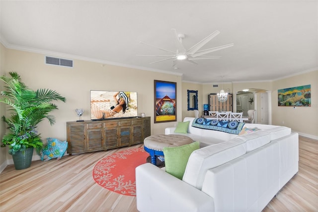 living room featuring ceiling fan with notable chandelier, light wood-type flooring, and ornamental molding