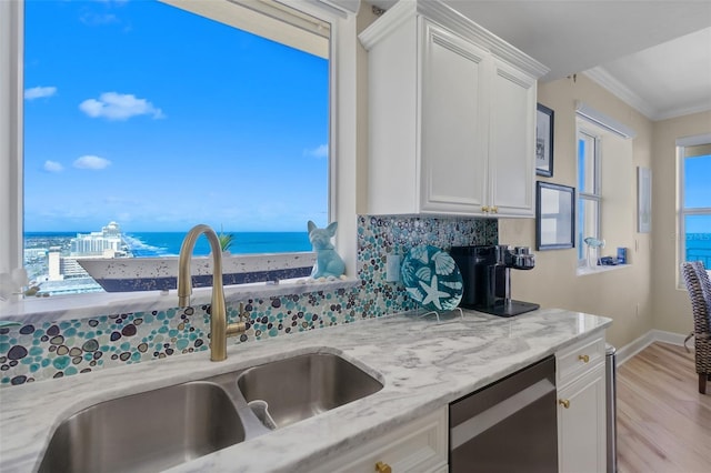 kitchen with dishwasher, a water view, sink, light stone counters, and white cabinetry