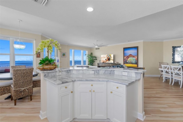 kitchen featuring white cabinetry, a water view, hanging light fixtures, and ceiling fan