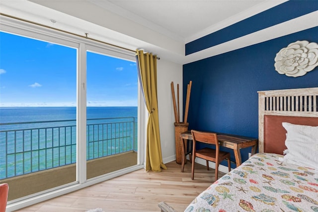 bedroom with access to outside, crown molding, a water view, and hardwood / wood-style flooring