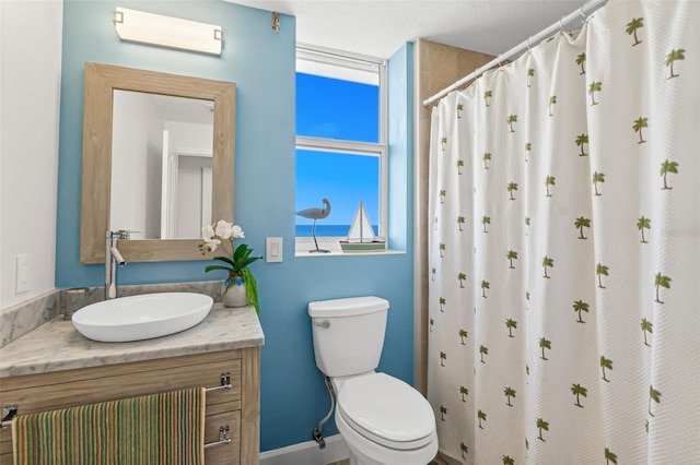 bathroom with vanity, curtained shower, and toilet