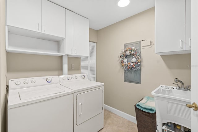 washroom featuring cabinets, separate washer and dryer, sink, and light tile patterned floors