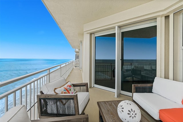 balcony featuring a water view and a view of the beach