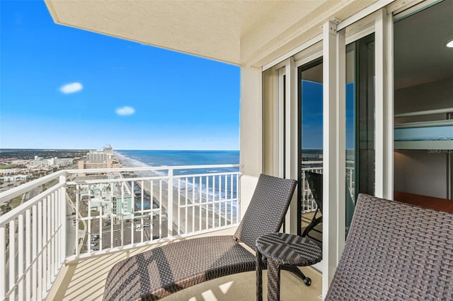 balcony with a water view and a view of the beach