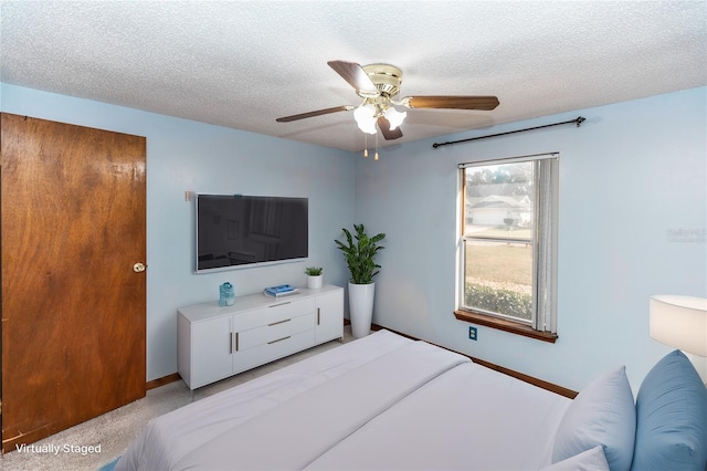 bedroom featuring light carpet, ceiling fan, and a textured ceiling