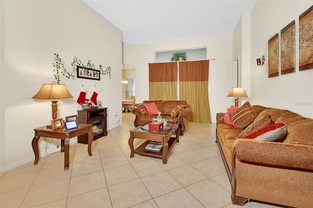 living area with arched walkways and light tile patterned flooring