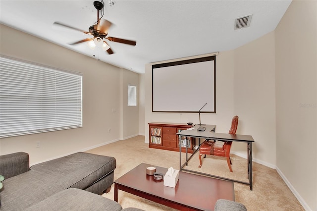 cinema room featuring light colored carpet and ceiling fan