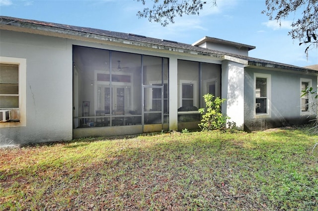 rear view of house with a sunroom and a yard