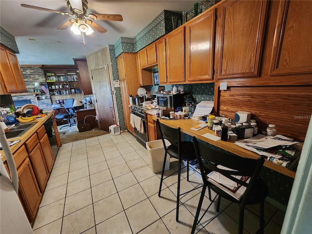 kitchen with ceiling fan, light tile patterned floors, and black appliances