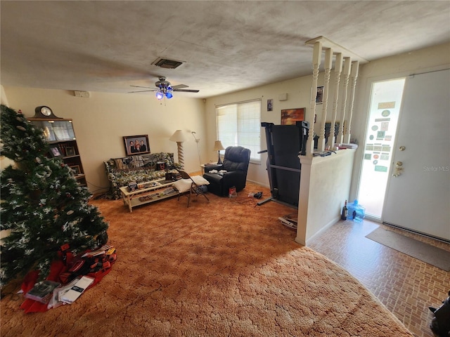 living room featuring ceiling fan and carpet