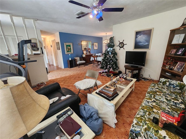 carpeted living room with ceiling fan with notable chandelier