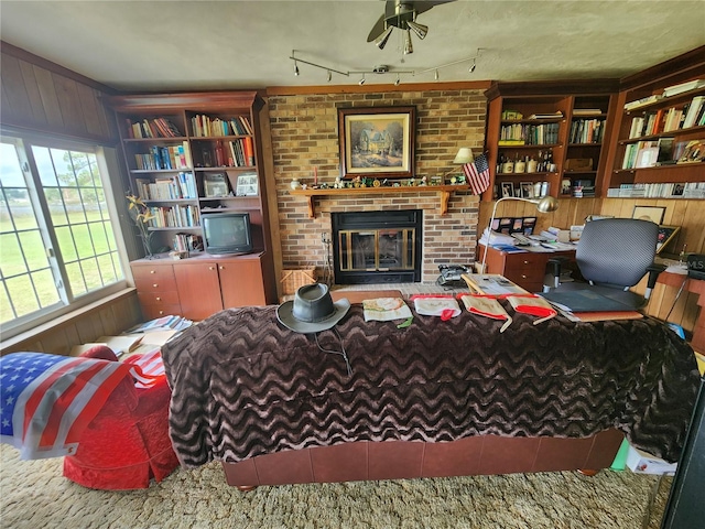 living room featuring wooden walls, a fireplace, and ceiling fan