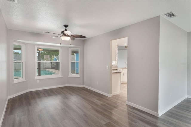 spare room featuring a textured ceiling, dark hardwood / wood-style floors, and ceiling fan