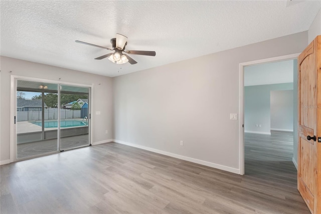 spare room featuring hardwood / wood-style flooring, ceiling fan, and a textured ceiling