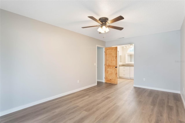 empty room featuring light wood-type flooring and ceiling fan