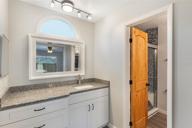 bathroom featuring vanity, ceiling fan, an enclosed shower, and wood-type flooring