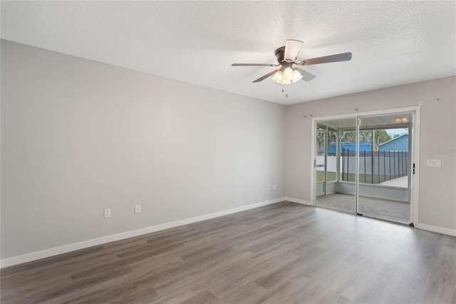 spare room with a textured ceiling, ceiling fan, and dark wood-type flooring