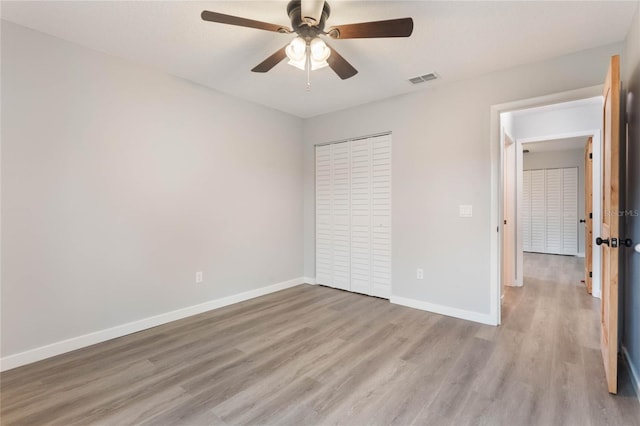 unfurnished bedroom with ceiling fan, light hardwood / wood-style flooring, and a closet