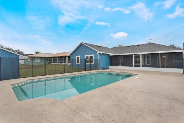 view of swimming pool with a sunroom, a patio area, and a yard