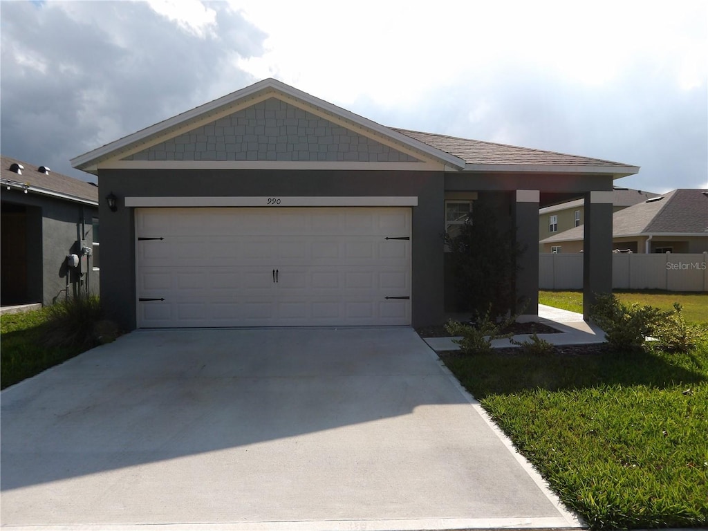 ranch-style house with a garage and a front lawn