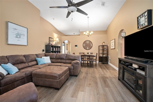 living room featuring ceiling fan with notable chandelier, light wood-type flooring, and lofted ceiling