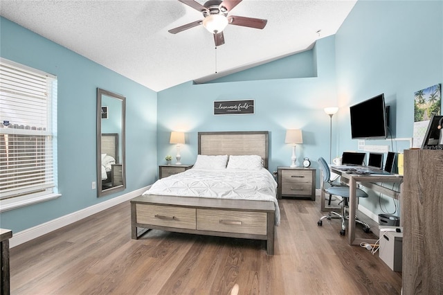 bedroom with a textured ceiling, ceiling fan, dark hardwood / wood-style flooring, and vaulted ceiling