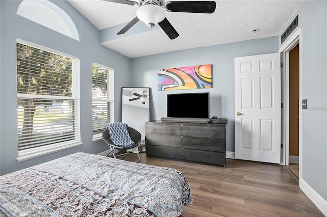 bedroom featuring ceiling fan, dark hardwood / wood-style floors, and a textured ceiling