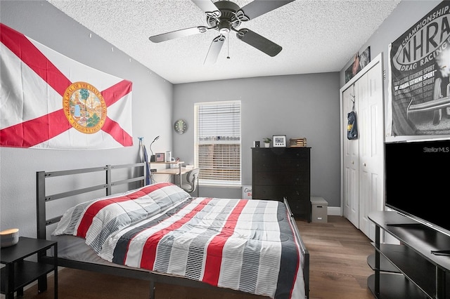 bedroom with ceiling fan, a closet, a textured ceiling, and hardwood / wood-style flooring