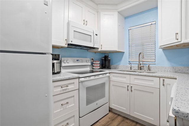 kitchen featuring sink, white appliances, white cabinets, and light stone countertops